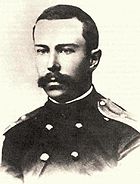 A teenage man with a full but neatly trimmed moustache, wearing a dark naval uniform