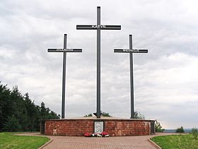 A Memorial consisting of three crosses standing on a large brick pedestal. Each cross bears a name – Katyn, Kharkiv, or Mednoye.