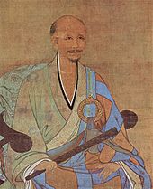 A portrait of an older, balding man in a half pale green and half sky blue robe. He is sitting on an armchair holding a thin wooden stick, possibally a folded up fan.