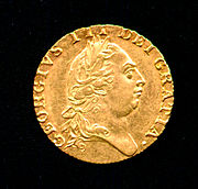 Moneda de oro que lleva el perfil de un hombre de cabeza redonda que llevaba un corte de pelo al estilo romano clásico y corona de laurel.