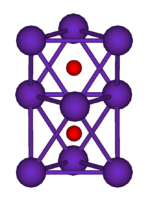 El diagrama de bola y palo muestra dos octaedros regulares que están conectados entre sí por una cara. Todos los nueve vértices de la estructura son esferas de color púrpura que representan rubidio, y en el centro de cada octaedro es una pequeña esfera roja que representa oxígeno.