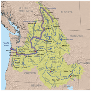 Mapa de tres colores de la cuenca del río Columbia. La cuenca tiene forma más o menos como un embudo con su extremo ancho hacia el este y el extremo estrecho a lo largo de la frontera entre Washington y Oregón ya que se acerca el Océano Pacífico. La cuenca se extiende hasta los estados de Estados Unidos occidentales de Washington, Oregon, Idaho, Nevada, Utah, Wyoming y Montana, y la provincia canadiense de Columbia Británica hacia el este hasta la frontera con Alberta. El propio río hace una curva cerrada desde el noroeste al sur, en la Columbia Británica y otro giro brusco de sur a oeste, ya que se acerca a Oregon.