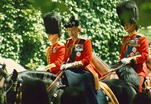 Elizabeth en uniforme rojo en un caballo negro