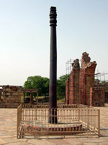 Un pilar, ligeramente estriado, con algunos ornamentos en su parte superior. Es negro, ligeramente degradado a un marrón oscuro cerca de la base. Es en torno a 7 metros (22 pies) de altura. Se alza sobre una base circular elevada de piedra, y está rodeado por un corto, cerca plaza.