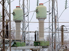 minaret-like electrical things with wires running around and fat at the bottom