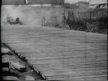 Une voiture évite le pont de bois avant de revenir en arrière et de continuer sa route sur le pont.