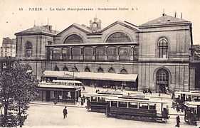 Vue extérieure de la gare. Devant celle-ci, sur la place De Rennes, plusieurs tramways.