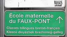 Panneau de signalisation routière, indiquant : « École maternelle du Faux-Pont, classes bilingues breton-français, Klasoù divyezhek brezhoneg-galleg ».