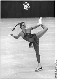 Photo en noir et blanc d'une patineuse se tenant la jambe gauche.