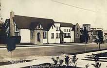 Photographie d'une rue bordée de bâtiments en brique à deux étages