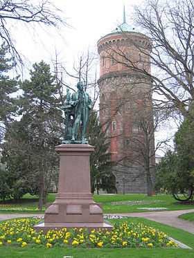 La statue d'Auguste Bartholdi avec le château d'eau en arrière-plan.