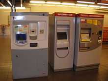 Vue des distributeurs de tickets dans une station de métro souterraine.