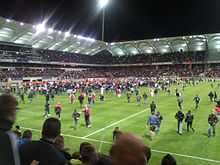 Pelouse d'un stade envahie de spectateurs