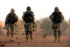 Photo de soldats polonais au Tchad avec leur véhicule de transport blindé.