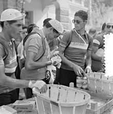 Fausto Coppi, entouré de Giovanni Corrieri et Mario Baroni, mange une orange durant le Tour de France 1952