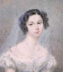 Portrait peint en couleurs d'une femme, teint pâle, cheveux noir avec des anglaises sur les côtés, portant un voile léger de couleur claire ; signature en noir en bas à droite : Sowgen 1825