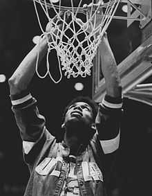 Lew Alcindor découpe le filet du panier, les yeux vers le haut.