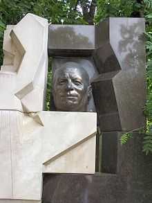 Photographie d'une sculpture représentant le visage de Khrouchtchev semblant percer un mur blanc et noir.