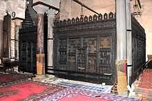 Photographie de la façade de la maqsura, clôture en bois de cèdre sculpté, située au fond de la salle de prière.