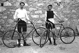 Photo des atlètes français Léon Flameng et Paul Masson, debout, tenant chacun leur vélos.