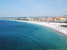 Vue orientée ouest depuis un quai de la baie et de la plage de Nice.