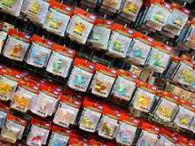 Photo de figurines de plusieurs Pokémon dans des cartons d'emballage sur un linaire.