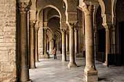 Vue intérieure du portique sud qui sert de narthex à la salle de prière. Les colonnes des arcades présentent des bases et des chapiteaux variés.
