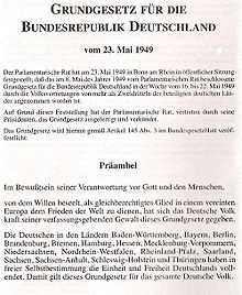 Première page du texte de la loi fondamentale de la république fédérale d'Allemagne, en allemand. En haut de la page, centré et en gras, l'intitulé : Loi fondamentale de la république fédérale allemande du 23 mai 1949. Après 9 lignes de texte dactylographié, centrées et dans un police non accentuée, le titre Préambule, centré et en gras, se trouve au milieu de l'image ; suivent les premiers paragraphes du texte du préambule, dans une police non accentuée.