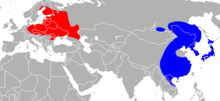 Planisphère de couleur grise représentant la présence du Chien viverrin dans le monde (Asie de l'Est en bleu et Europe de l'Est en rouge).