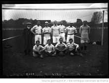 Photo d'équipe sur deux rangs, les joueurs du premier rang étant assis. L'équipe est placée devant l'un des buts.