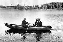 Photographie d'un petit canot sur un lac dans lequel se trouvent trois personnes. Khrouchtchev est en train de ramer.