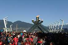 Photographie de la foule massée au pied le vasque olympique.