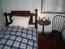 Photo en couleur d'une chambre avec un lit, une table et une chaise