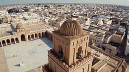 Photographie aérienne de la Grande Mosquée de Kairouan, montrant de près le dernier niveau du minaret qui correspond au lanternon. Celui-ci est surmonté d’une coupole.