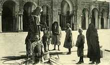 Carte postale de 1900 montrant l’utilisation, par des pèlerins, d’un puits situé dans la cour de la mosquée.