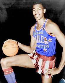 Photo en demi grandeur d'un basketteur noir tenant avec un ballon sur sa cuisse droite