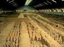 Photographie des soldats de l'armée en terre cuite dans une fosse couverte d'un hangar immense.